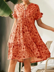 Détail d'une robe d'été à fleurs avec col en V boutonné et manches à volants