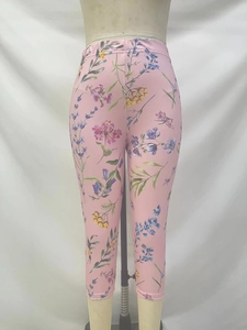 Gros plan du legging de yoga taille haute avec imprimé floral rose sur tissu élastique