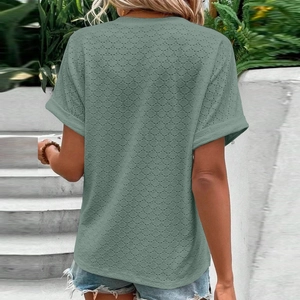 Detail of sage green short sleeve top with delicate eyelet embroidery and rolled cuffs