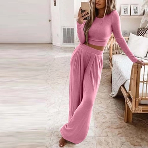 Pink knit two-piece lounge set with long sleeve crop top and high-waisted wide-leg pants