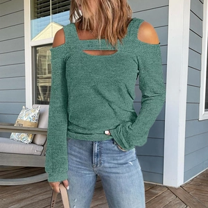 Close-up of cold shoulder design and horizontal cutout neckline on dark green top