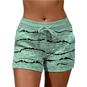 Détail d'un short de yoga avec motifs à vagues vertes, cordon et poches latérales