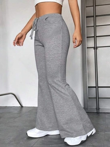 Détail du pantalon de yoga gris évasé à taille haute avec cordon et texture en tricot