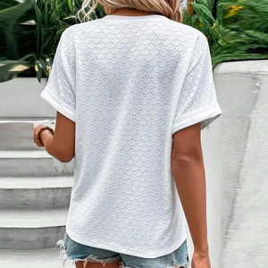 Detail of white eyelet fabric on short sleeve top showing breathable circular embroidery