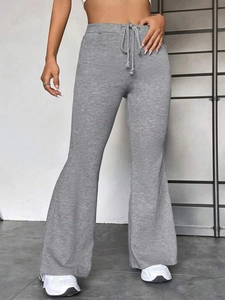 Détail du pantalon de yoga gris évasé avec taille élastique à cordon et fente latérale