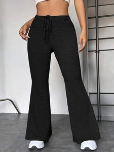 Détail du pantalon de yoga évasé à taille haute avec cordon de serrage et poches invisibles