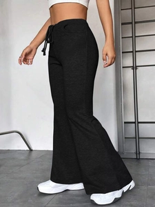 Détail du pantalon de yoga évasé noir avec taille à cordon et mélange de coton doux