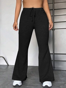 Détail de la taille haute à cordon sur le pantalon évasé noir pour sport et yoga