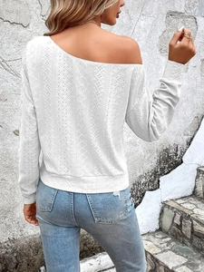 Détail du haut blanc à épaule dénudée avec des motifs géométriques en tricot ajouré fin
