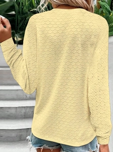 Detailed back view of light yellow long sleeve top featuring hollow geometric textures