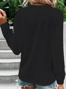 Back view of a slim fit black long sleeve top with waffle texture and round neckline