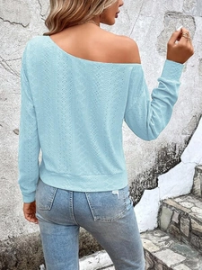 Détail du haut bleu clair à épaules dénudées avec texture en maille ajourée délicate