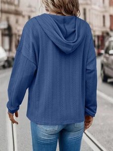 Rear view of a navy blue oversized hoodie with textured knit vertical stripe patterns