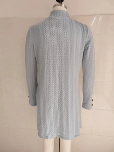Detailansicht der hellblauen Stricktextur und dekorative Knöpfe am Ärmelbündchen