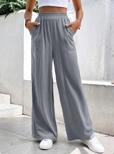 Dettaglio dei pantaloni a vita alta con elastico in vita e grandi tasche applicate