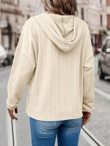 Close-up of beige hooded sweatshirt featuring unique 3D vertical geometric textured knit fabric