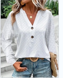Detail of white V-neck long sleeve top featuring intricate hollow out crochet patterns