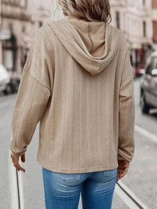 Detail of khaki textured knit hoodie with drop shoulder and herringbone fabric pattern