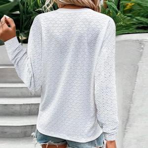 Detail of white long sleeve top featuring eyelet hollow texture and a round neck design