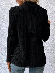 Detail of ribbed knit texture on the back of a black long-sleeve winter cardigan sweater