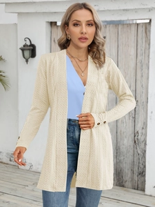Details des hellbeigen Strickmantels mit Strukturstoff und schwarzen Knöpfen am Ärmel
