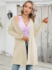 Detail der cremefarbenen Strickjacke mit Wellenstruktur und Knöpfen an den Ärmeln