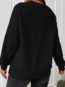 Detail of waffle knit texture on women's black drop-shoulder long sleeve sweatshirt
