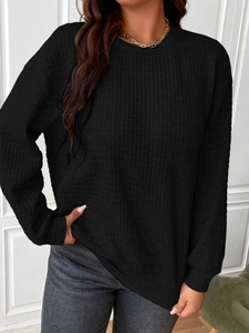 Detail shot of the black waffle knit texture and ribbed cuffs on a long-sleeved sweatshirt