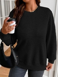 Close-up of black waffle-knit sweatshirt with crewneck and soft textured fabric detail