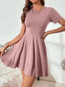 Vue détaillée d'une robe rose à manches courtes avec taille haute et jupe plissée