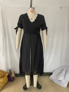 Détail du décolleté en V festonné et des nœuds aux poignets sur une robe noire