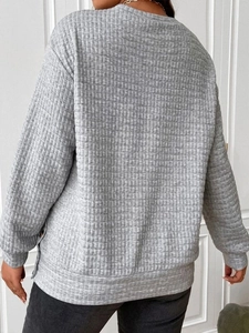 Detailed view of grey waffle knit texture and stitching on casual round neck sweatshirt