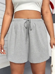 Close-up of grey drawstring sports shorts featuring elastic waist and cotton blend texture