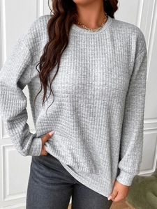 Close-up of grey waffle knit texture on a crewneck long-sleeved pullover sweatshirt
