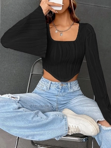 Detail of black long sleeve crop top with U-neck and triangular hem on ribbed fabric