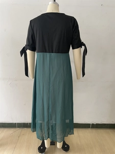 Détail d'une robe mi-longue bicolore avec manches à nœuds et jupe en mousseline vert foncé