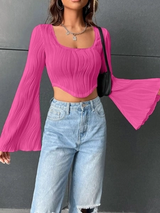 Detail of rose pink pleated crop top with dramatic bell sleeves and curved hem