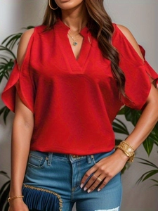 Detail of red V-neck top with cut-out cold shoulder sleeves and gold jewelry