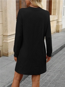 Detail view of black long sleeve dress featuring unique chevron knit texture and slim fit design
