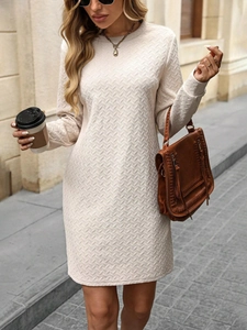 Detail shot of beige knit dress showing textured wavy pattern and crew neck design
