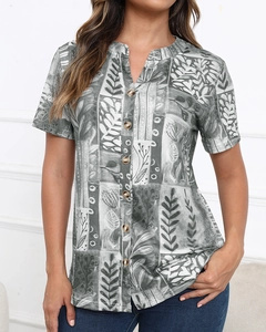 Detail of V-neck printed short sleeve top with tropical leaf pattern and front buttons