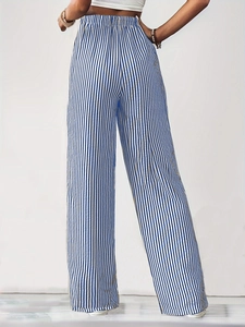 Detail view of the elastic waistband and vertical blue stripes on wide-leg trousers