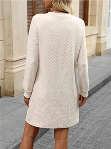 Close-up of the textured wave-knit pattern on the back of this cream long sleeve dress