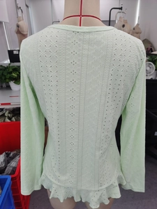 Vue détaillée du haut en dentelle vert clair avec motifs géométriques et ourlet volanté