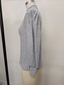 Detail of grey ribbed knit texture and stylish puff shoulder design on a long sleeve top