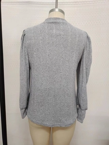 Detail view of light grey ribbed knit long sleeve shirt with subtle puff shoulder design