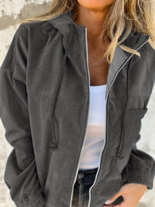 Detail of dark grey corduroy jacket featuring a hood with drawstring and metal zipper