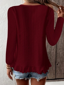 Détail du haut en tricot ajouré bordeaux avec motif œillets et ourlet à volants au dos