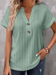 Detailed close-up of V-neckline with buttons on sage green textured short sleeve top