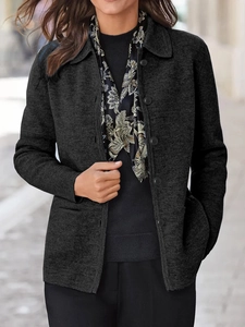 Detailaufnahme der dicken dunkelgrauen Bluse mit Knopfleiste und Blumenschal-Akzent